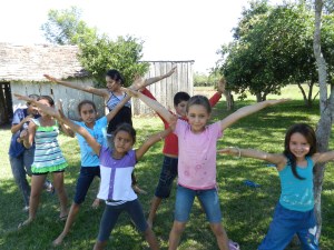 Kids' Club making the Letter X for the camera while they practice their alphabet.