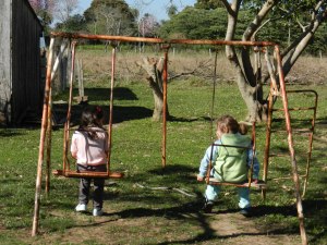 Girls swinging at the school playground, which is also my backyard. El Dia de Los Niños