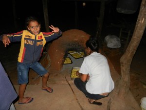 Cooking chipa (traditional Paraguayan bread) in the tatakua. First you build a fire and get the bricks REALLY hot, then remove the coals and add the pans of bread, which bake from the residual heat. These ovens are made of bricks and mud and last for years if protected from rain.